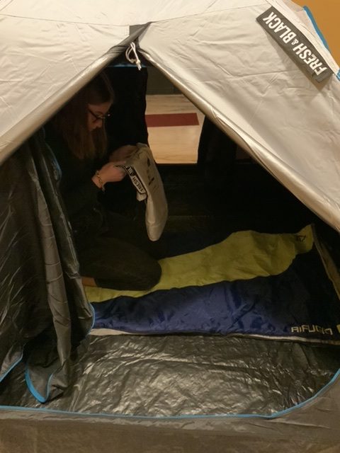 Anna inside the tent with the sleeping bag